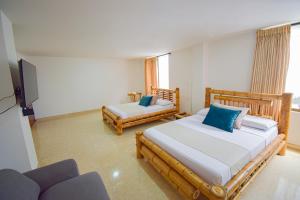 Hotel Toledo Plaza في أرمينيا: غرفة نوم بسريرين وتلفزيون وأريكة