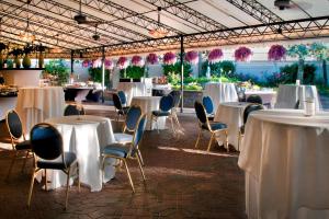 een kamer met tafels en stoelen met witte tafelkleden bij Westchester Marriott in Tarrytown