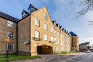 a large brick building with a large garage at Entire 2 Bed Flat Contractors Families and Relocators in Ware