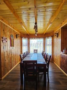Casa familiar en Isla Lemuy في Puqueldón: غرفة طعام خشبية مع طاولة وكراسي طويلة