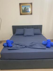 a bed with blue sheets and blue pillows on it at Chlo apartment 4 Tirane in Tirana