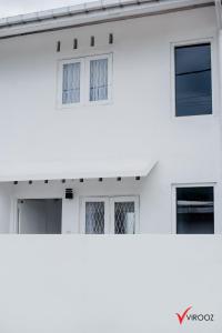 a white building with four windows on it at Virooz Residence Rathmalana 2 Bedroom Apartment in Borupane