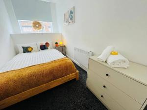- une chambre blanche avec un lit et une commode dans l'établissement Artistic 1Bed Apt near the City Centre, à Liverpool