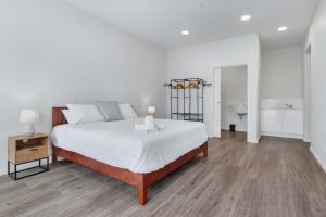 a white bedroom with a large bed and a table at York St Apartments in Geelong