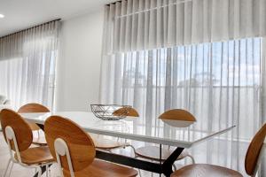 a dining room with a glass table and chairs at York St Apartments in Geelong
