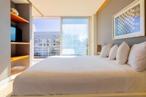 een groot wit bed in een kamer met een groot raam bij Capitalia San Angel Inn in Mexico-Stad +31 foto's