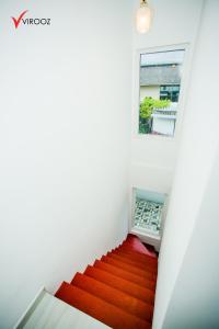 a staircase with a red carpet and a window at Virooz Residence Rathmalana 2 Bedroom Apartment in Borupane