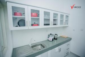 a kitchen with white cabinets and a sink at Virooz Residence Rathmalana 2 Bedroom Apartment in Borupane