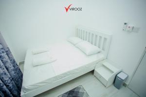 Cama blanca con almohadas blancas y silla en Virooz Residence Rathmalana 2 Bedroom Apartment en Borupane