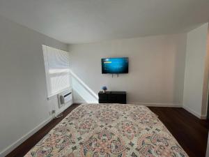 a bedroom with a bed with a tv on the wall at La Unica in Austin