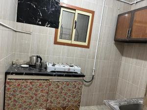 uma pequena cozinha com um fogão e uma janela em 14 Min from cairo airport no Cairo