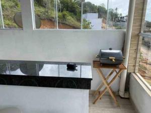 a grill sitting on a table next to a window at Casa de Veraneio IOS in Ilhéus