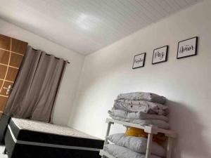 a bedroom with a stack of pillows on a shelf at Casa de Veraneio IOS in Ilhéus
