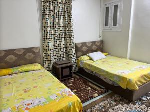 um quarto com 2 camas individuais e uma janela em 14 Min from cairo airport no Cairo