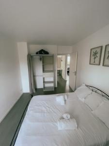 białe łóżko z dwoma ręcznikami w sypialni w obiekcie Appartement Proche U Arena et La Défense w mieście Nanterre +24 zdjęcia