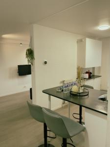 kuchnia ze stołem i krzesłami w pokoju w obiekcie Appartement Proche U Arena et La Défense w mieście Nanterre