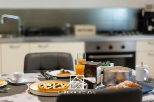 LIBERA HOUSE - Sweet Apartments في سان سالفو: طاولة عليها أطباق من الطعام وعصير البرتقال