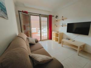 a living room with a couch and a flat screen tv at Poris puesta de sol 2 in Santa Cruz de Tenerife