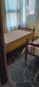 a bed sitting in a room with a window at cabañas aromas de las sierras in El Volcán