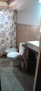 a bathroom with a toilet and a sink at cabañas aromas de las sierras in El Volcán