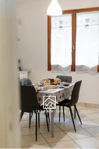 a dining room table with black chairs and a table and chairsktop at LIBERA HOUSE - Sweet Apartments in San Salvo