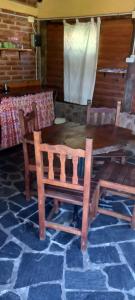 a wooden table with chairs and a table and a table at cabañas aromas de las sierras in El Volcán