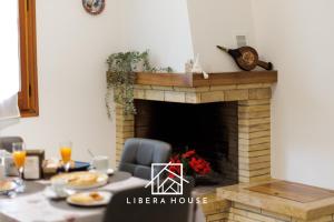 LIBERA HOUSE - Sweet Apartments في سان سالفو: غرفة طعام مع موقد وطاولة طعام مع طاولة