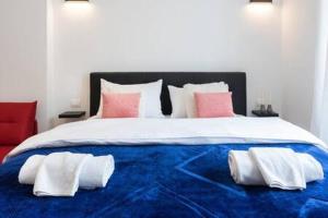 a large bed with white and pink pillows on it at Lux Nest II City Apartment URBAN STAY in Zagreb