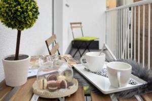 a wooden table with two cups and a plate of food at Lux Nest I City Apartment URBAN STAY in Zagreb