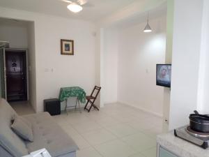 a living room with a couch and a table at Apartamento do Bruno - 1 quarto e sala predio vista ao mar- frente a praia do gonzaga in Santos