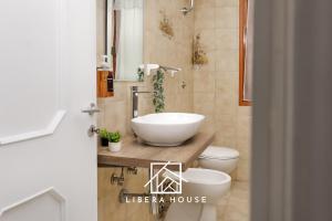 LIBERA HOUSE - Sweet Apartments في سان سالفو: حمام مع حوض ومرحاض