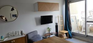 ein Wohnzimmer mit einem Stuhl, einem Tisch und einem Spiegel in der Unterkunft Studio Victoria Centre Grande Plage and Pool in Biarritz