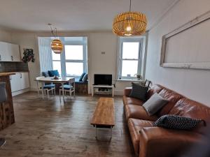 a living room with a couch and a table at Lovely Seafront 2 bed flat in Aberystwyth in Aberystwyth