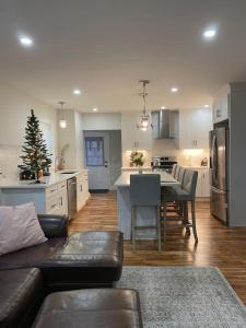 a living room with a couch and a kitchen with a christmas tree at Stunning and Beautiful 4 beds, 3 bath house located in Quincy near Quincy Adam RED LINE transit in Quincy