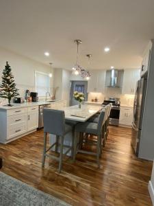 Il comprend une cuisine équipée d'une table, de chaises et d'un réfrigérateur. dans l'établissement Stunning and Beautiful 4 beds, 3 bath house located in Quincy near Quincy Adam RED LINE transit, à Quincy