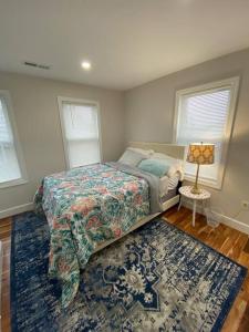 ein Schlafzimmer mit einem Bett und einem blauen Teppich in der Unterkunft Stunning and Beautiful 4 beds, 3 bath house located in Quincy near Quincy Adam RED LINE transit in Quincy