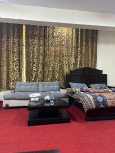 uma sala de estar com um sofá e uma cama em Islamabad lodges apartment suite em Islamabad
