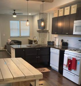 a kitchen with black cabinets and a wooden table at Housepitality - The Urban Roost 2 - Location in Columbus