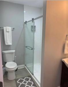 a bathroom with a toilet and a glass shower at Housepitality - The Urban Roost 2 - Location in Columbus