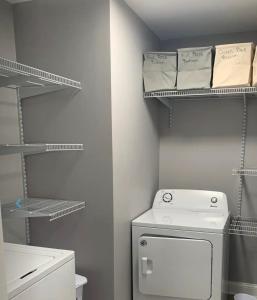 a small bathroom with a toilet and a shelf at Housepitality - The Urban Roost 2 - Location in Columbus