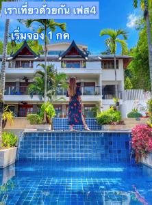 a woman sitting on a bench next to a swimming pool at Baan Yin Dee Boutique Resort Phuket - SHA Plus in Patong Beach