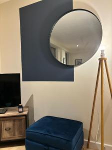 uma sala de estar com um repousa-pés azul e um espelho em Modern 2 BDR Flat in Nottingham City Centre with free parking em Nottingham