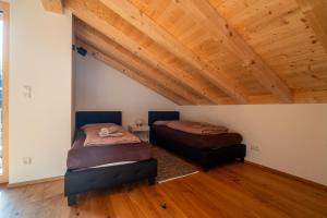 two beds in a room with a wooden ceiling at Neu! Auszeit in der Bergen in Wertach