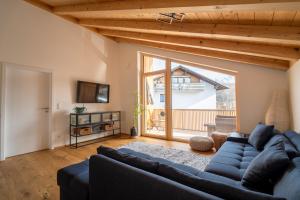 a living room with a blue couch and a large window at Neu! Auszeit in der Bergen in Wertach