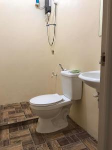 a bathroom with a toilet and a sink at Palermos IslandVille in Catarman