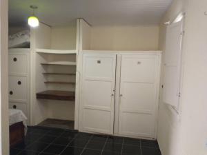 um quarto com armários e prateleiras brancas e piso em azulejo em Casa Delicia em Passa Quatro Até 4 pessoas em Passa Quatro