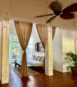 a bedroom with a bed and a ceiling fan at Casa Airam Beachfront Villa in Sian Kaan in Tulum