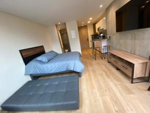 1 dormitorio con cama y escritorio. en PENTHOUSE Centro Internacional Apartamento, en Bogotá