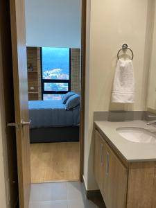 a bathroom with a view of a bed and a mirror at PENTHOUSE Centro Internacional Apartamento in Bogotá
