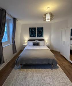 um quarto com uma cama grande com duas mesas e um lustre em City Nights - London em Londres